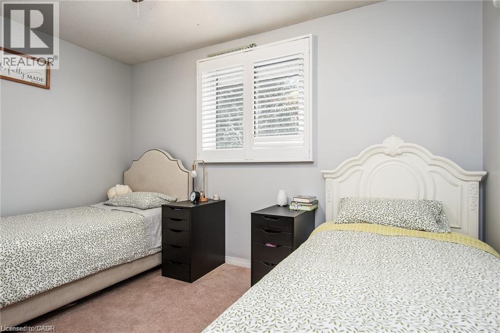 Room with light gray walls, plush carpeting, and a window fitted with white plantation shutters - 67 Pinemeadow Crescent, Waterloo, ON - Indoor Photo Showing Bedroom