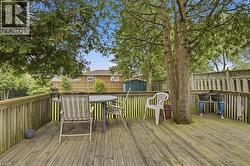 Spacious wooden deck with a built-in tree feature, complete with sturdy railing and a latticework fence -