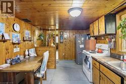 Pine wood paneling throughout, featuring a kitchen area with built-in cabinetry, a stainless steel sink, and durable countertops -