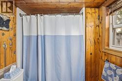 Bathroom featuring wood-paneled walls and ceiling -