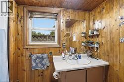 Bathroom featuring wood-paneled walls and ceiling -
