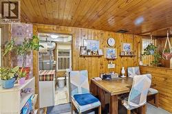 Dining area featuring wood-paneled walls and ceiling -