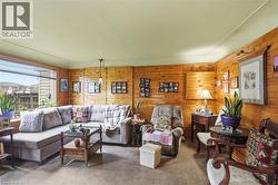 Interior room featuring wood-paneled walls and a large picture window -