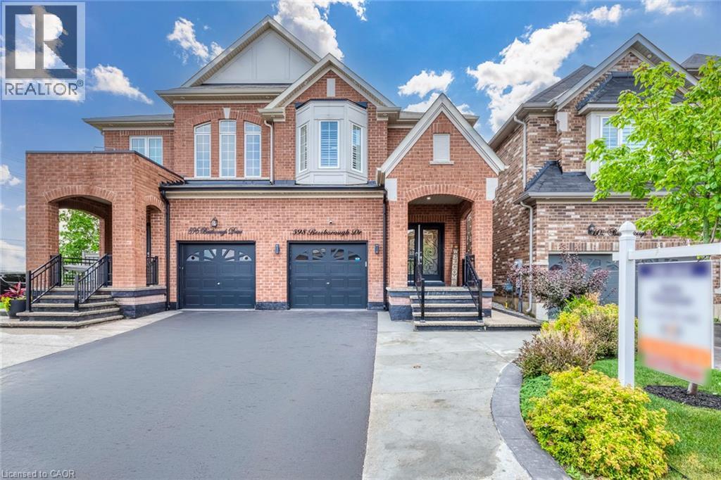 Brick facade residence featuring a two-car garage, bay window, and arched entryways - 598 Bessborough Drive, Milton, ON - Outdoor With Facade