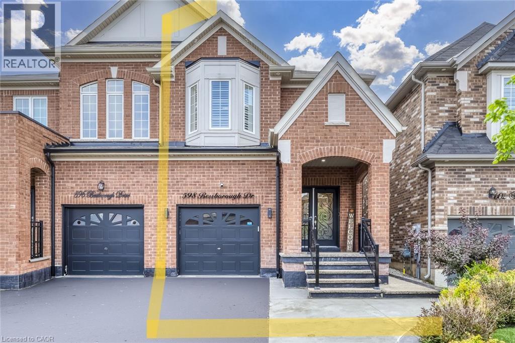 Brick facade residence featuring an arched portico, dual garage doors, and a bay window - 598 Bessborough Drive, Milton, ON - Outdoor With Facade