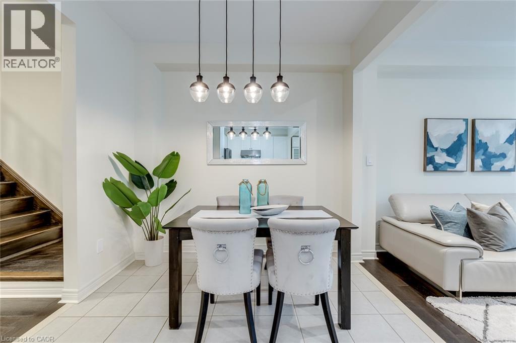 Dining area featuring recessed lighting, a modern four-light pendant fixture, and light-toned tile flooring - 598 Bessborough Drive, Milton, ON - Indoor Photo Showing Dining Room