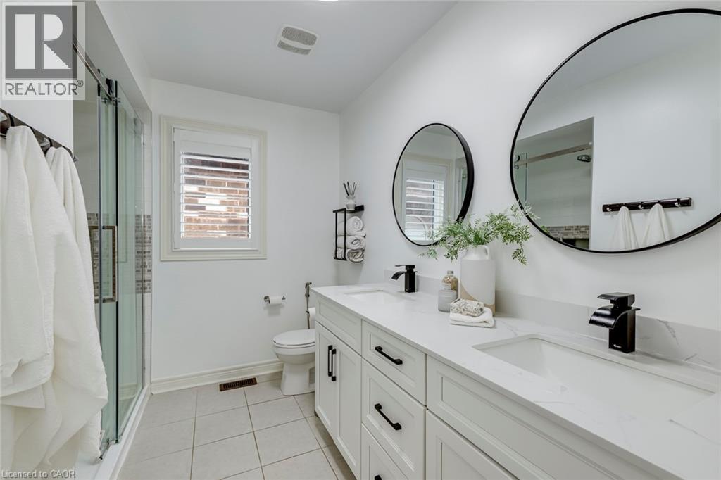 Double vanity with integrated sinks and black matte faucets - 598 Bessborough Drive, Milton, ON - Indoor Photo Showing Bathroom