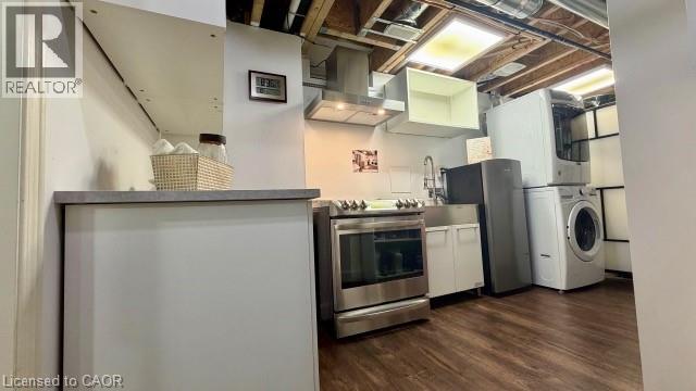 Stainless steel range with matching range hood, stainless steel sink, wood-finish flooring, and white cabinetry - 598 Bessborough Drive, Milton, ON - Indoor Photo Showing Laundry Room