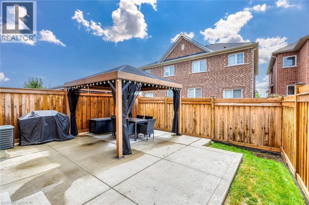 Paved patio with an integrated gazebo, surrounded by a wood privacy fence - 598 Bessborough Drive, Milton, ON - Outdoor With Exterior