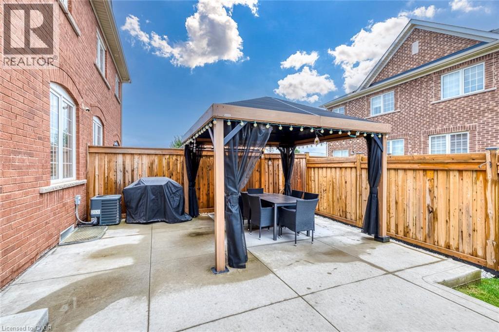 Paved patio area featuring a permanent gazebo structure with integrated lighting - 598 Bessborough Drive, Milton, ON - Outdoor With Exterior