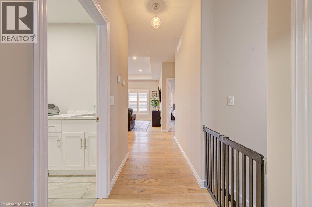 Hallway with wood-finish flooring, recessed lighting, and a visible railing - 15 Matheson Crescent, Innerkip, ON - Indoor Photo Showing Other Room