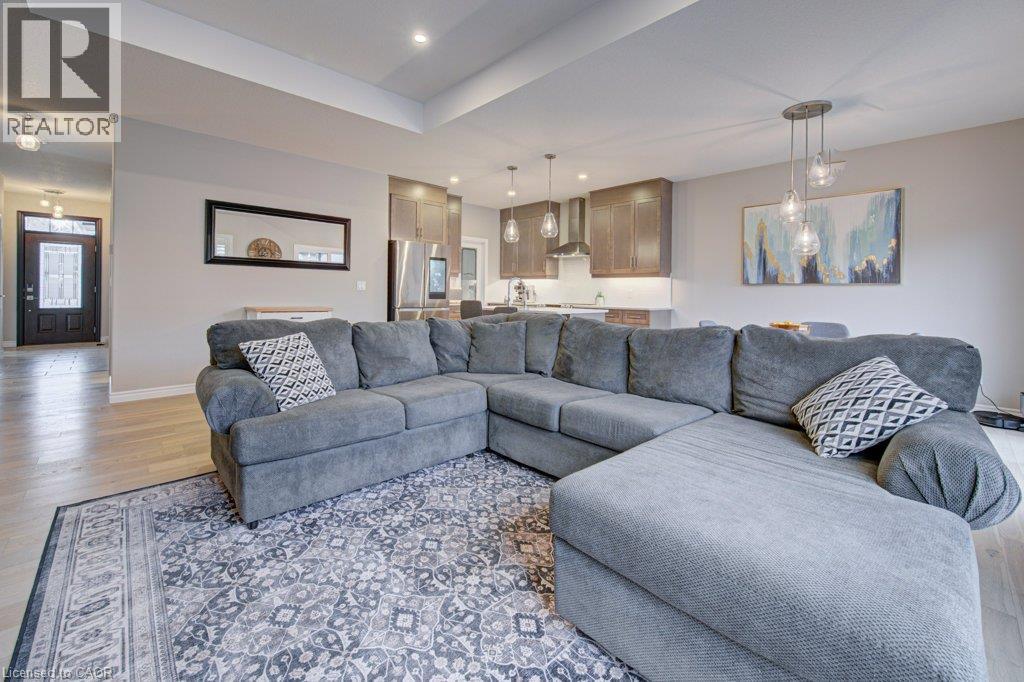 Open-concept living space featuring wood-finish flooring, recessed lighting, and a tray ceiling - 15 Matheson Crescent, Innerkip, ON - Indoor Photo Showing Living Room