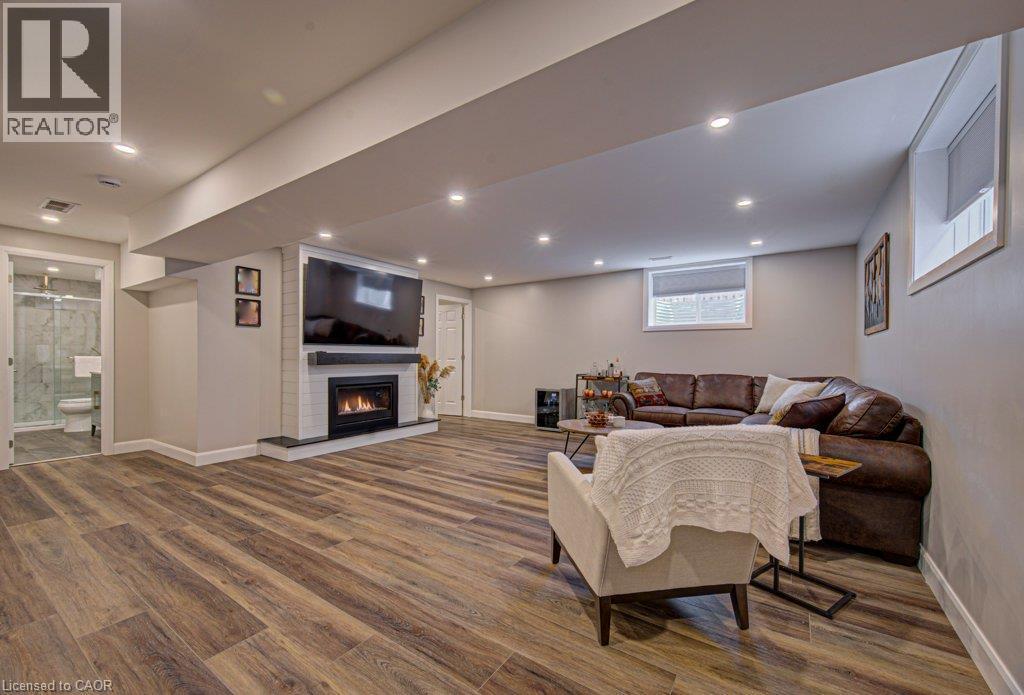 Spacious finished interior with wood-finish flooring, recessed lighting, and light gray wall paint - 15 Matheson Crescent, Innerkip, ON - Indoor With Fireplace