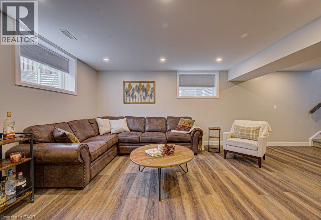 Spacious lower-level room featuring wood-finish flooring, recessed lighting, and neutral wall tones - 15 Matheson Crescent, Innerkip, ON - Indoor