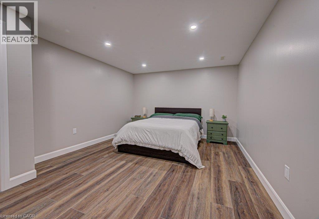 Spacious room featuring wood-finish flooring, recessed ceiling lighting, light gray walls, and white baseboards - 15 Matheson Crescent, Innerkip, ON - Indoor Photo Showing Bedroom