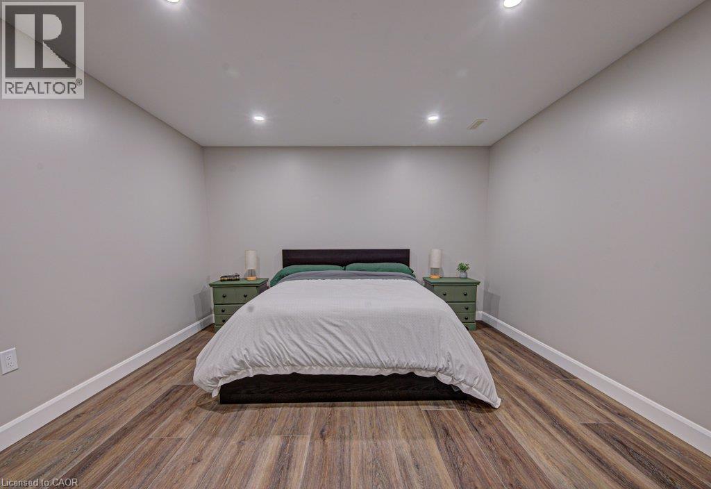 Spacious room with wood-finish flooring, recessed ceiling lighting, and crisp white baseboards - 15 Matheson Crescent, Innerkip, ON - Indoor Photo Showing Bedroom