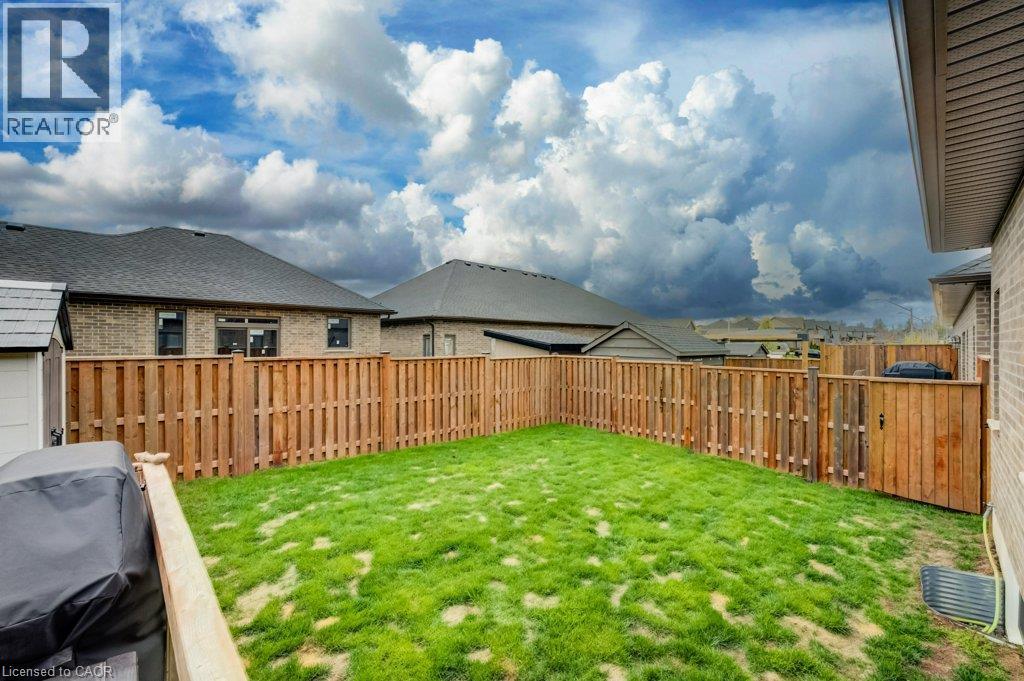 Private backyard featuring a wooden privacy fence, a well-maintained lawn, and a storage shed - 15 Matheson Crescent, Innerkip, ON - Outdoor