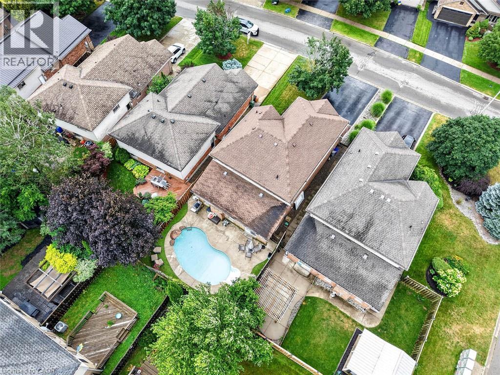 Backyard oasis featuring an irregular-shaped inground pool, paved patio, and mature landscaping - 43 Liam Drive, Ancaster, ON - Outdoor With View