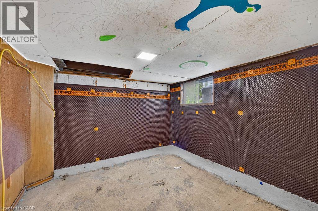 Basement space featuring dimpled membrane wall treatment, a small window, concrete flooring, and exposed ceiling joists - 23 Harrison Avenue, Hamilton, ON - Indoor Photo Showing Other Room