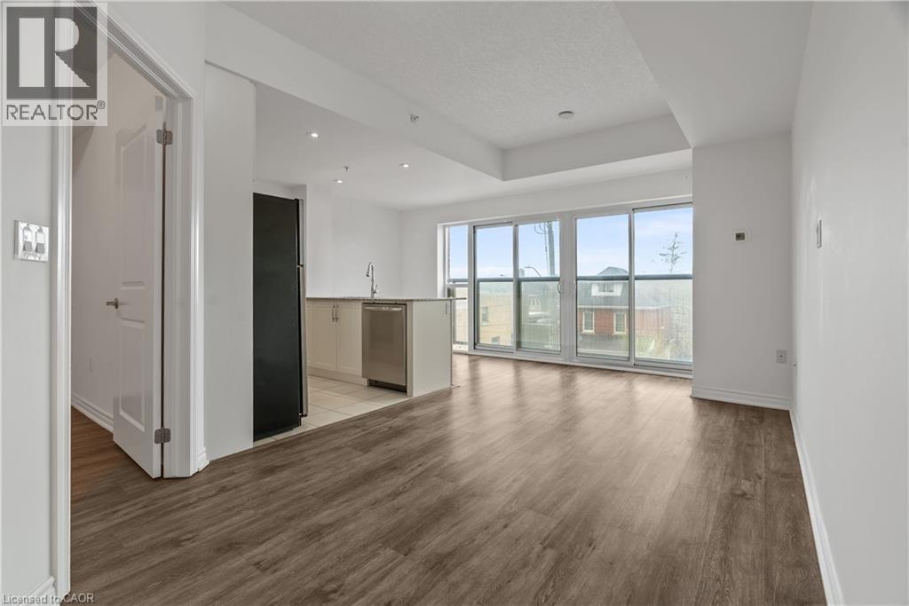 Open-concept living area with wood-finish flooring, recessed lighting, and expansive sliding glass doors - 427 Aberdeen Avenue Unit# 102, Hamilton, ON - Indoor Photo Showing Other Room