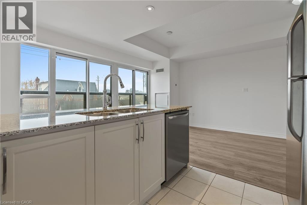 Kitchen featuring light cabinetry, granite countertops, stainless steel appliances, and a double basin sink with a high-arc faucet - 427 Aberdeen Avenue Unit# 102, Hamilton, ON - Indoor Photo Showing Kitchen With Double Sink