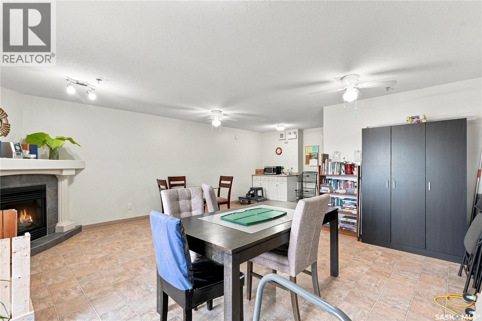 209 215 Lowe Road, Saskatoon, SK - Indoor Photo Showing Dining Room With Fireplace