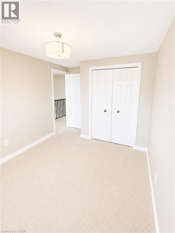 Carpeted room with neutral wall tones and white baseboards - Upper-313 Featherstone Crescent, Kitchener, ON - Indoor Photo Showing Other Room