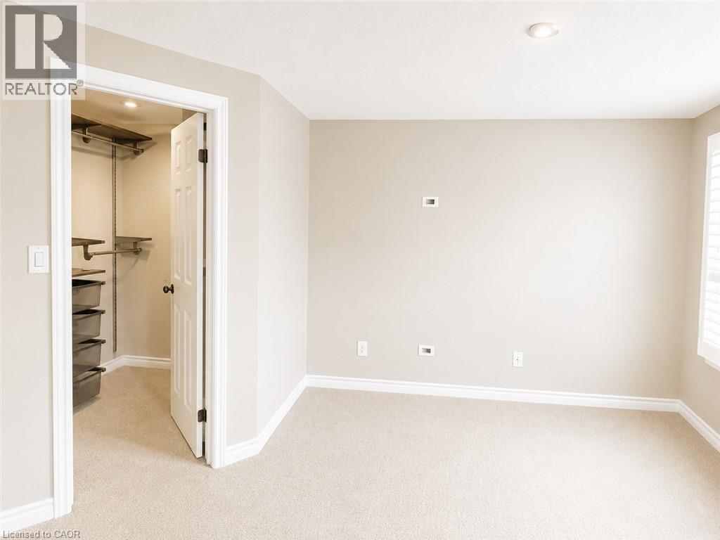 Room featuring neutral wall tones, recessed ceiling lighting, wall-to-wall carpeting, white baseboards, and a closet with built-in shelving - Upper-313 Featherstone Crescent, Kitchener, ON - Indoor Photo Showing Other Room