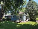 Spacious green lawn with mature shade trees surrounding a light blue exterior siding and white trim - 9 Norfolk Street N, Hamilton, ON  - Outdoor 