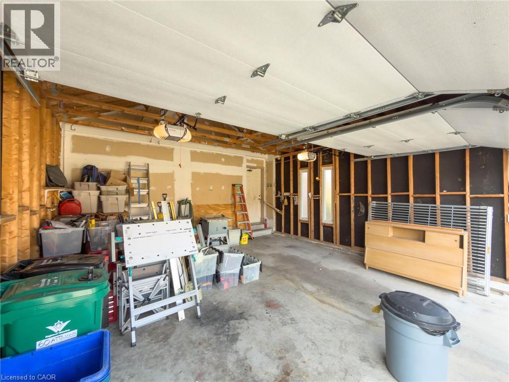 Spacious garage featuring concrete flooring, an automatic garage door opener, and visible framing ready for customization - 60 Attwood Drive, Cambridge, ON - Indoor Photo Showing Garage