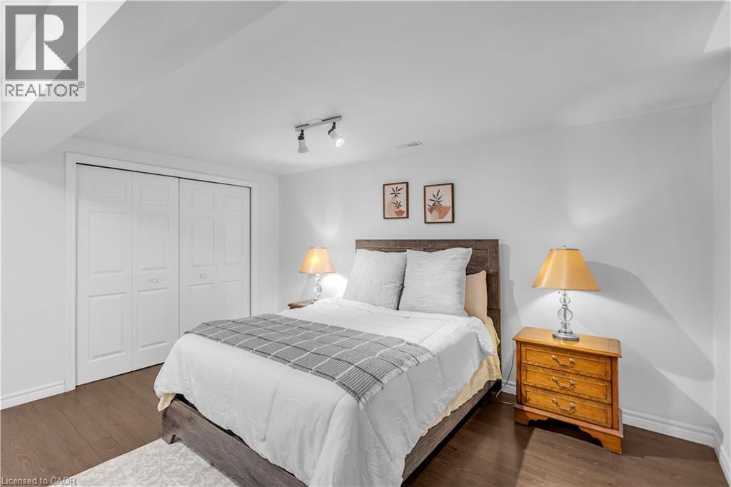 Spacious room featuring wood-finish flooring, white walls, and a large bi-fold closet - 65 Thistlemoor Drive, Caledonia, ON - Indoor Photo Showing Bedroom