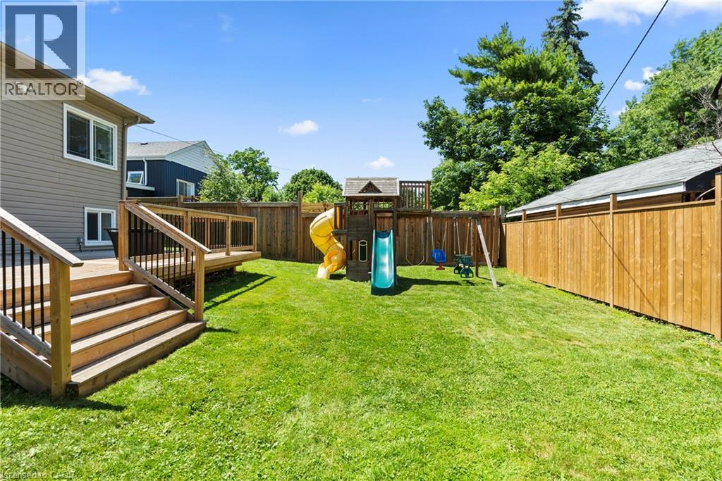 Expansive backyard featuring a large wooden deck with black metal balusters, privacy fencing, and green lawn space - 258 Sanatorium Road, Hamilton, ON - Outdoor With Deck Patio Veranda
