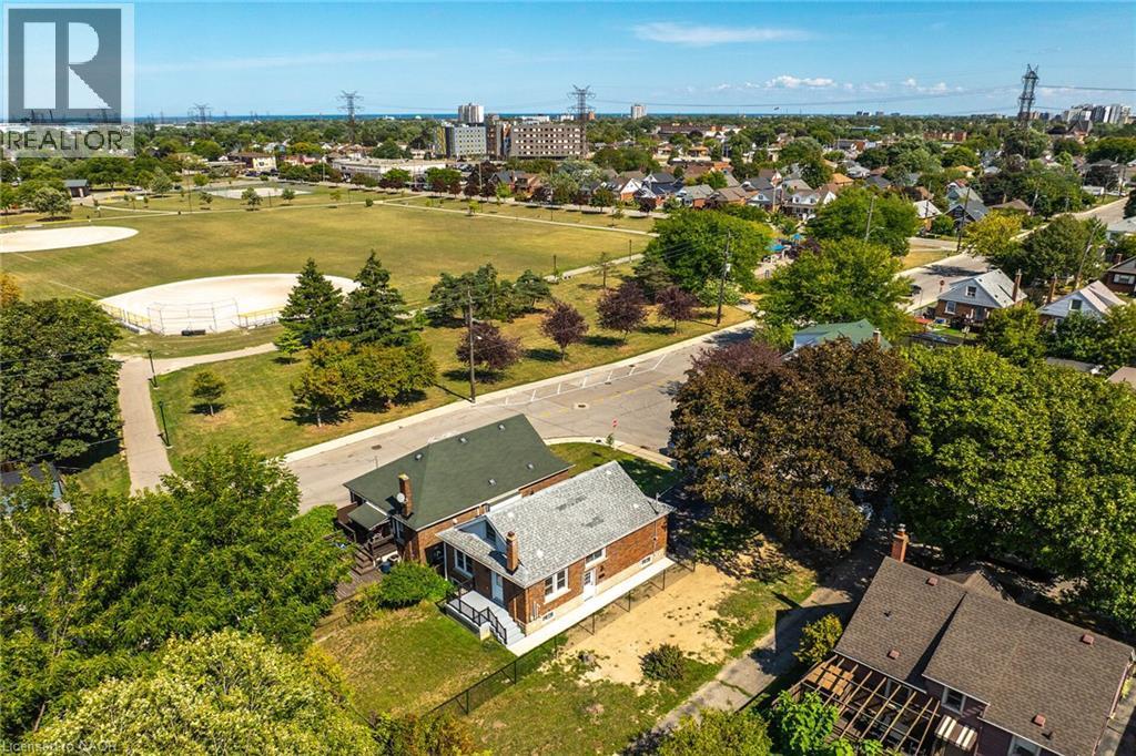 Aerial perspective showcasing a residential property with a brick exterior, a green asphalt shingle roof, and a gravel-covered yard - 128 Auburn Avenue, Hamilton, ON