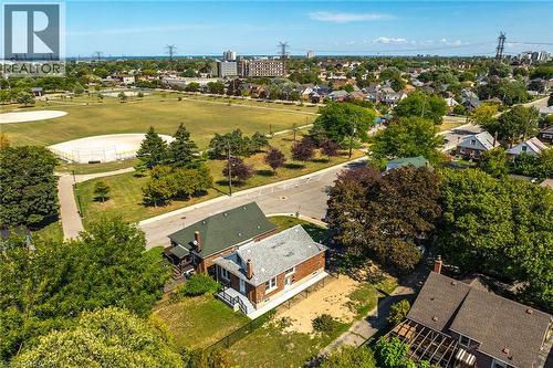 Aerial perspective showcasing a residential property with a brick exterior, a green asphalt shingle roof, and a gravel-covered yard - 128 Auburn Avenue, Hamilton, ON 