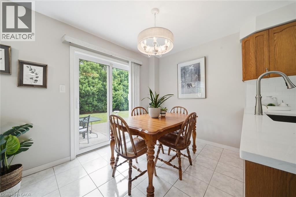 Dining area featuring a contemporary drum pendant light fixture, tile flooring, and a sliding glass door opening to the outdoors - 200 Morrison Drive, Caledonia, ON - Indoor Photo Showing Dining Room