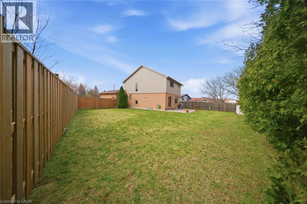 Spacious backyard featuring a manicured lawn, full privacy fencing, and mature perimeter evergreen landscaping - 200 Morrison Drive, Caledonia, ON - Outdoor