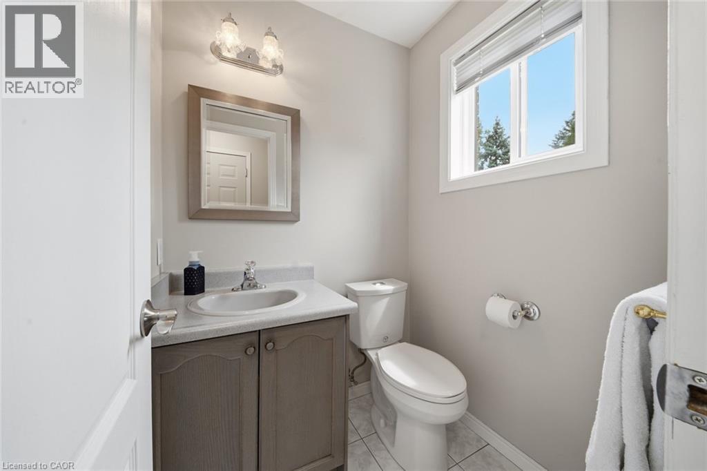 Bathroom featuring a single window, a vanity with a light-toned countertop and cabinet, an oval sink with a chrome faucet, and a wall-mounted light fixture - 200 Morrison Drive, Caledonia, ON - Indoor Photo Showing Bathroom