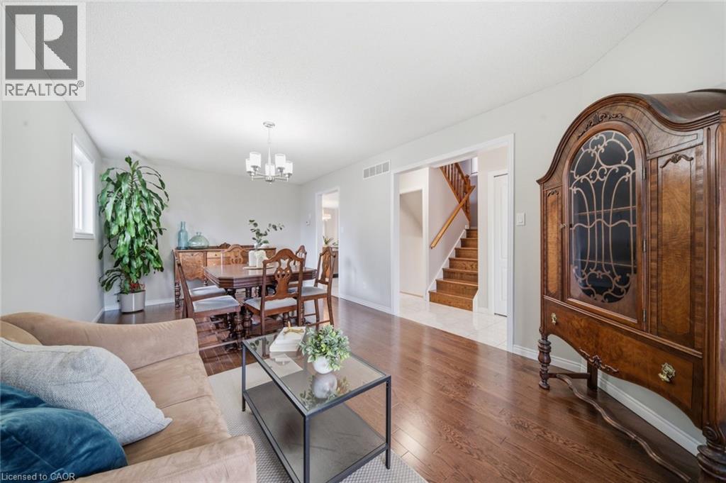 Open-concept living space with dark wood-finish flooring, light grey wall paint, and white trim - 200 Morrison Drive, Caledonia, ON - Indoor Photo Showing Living Room