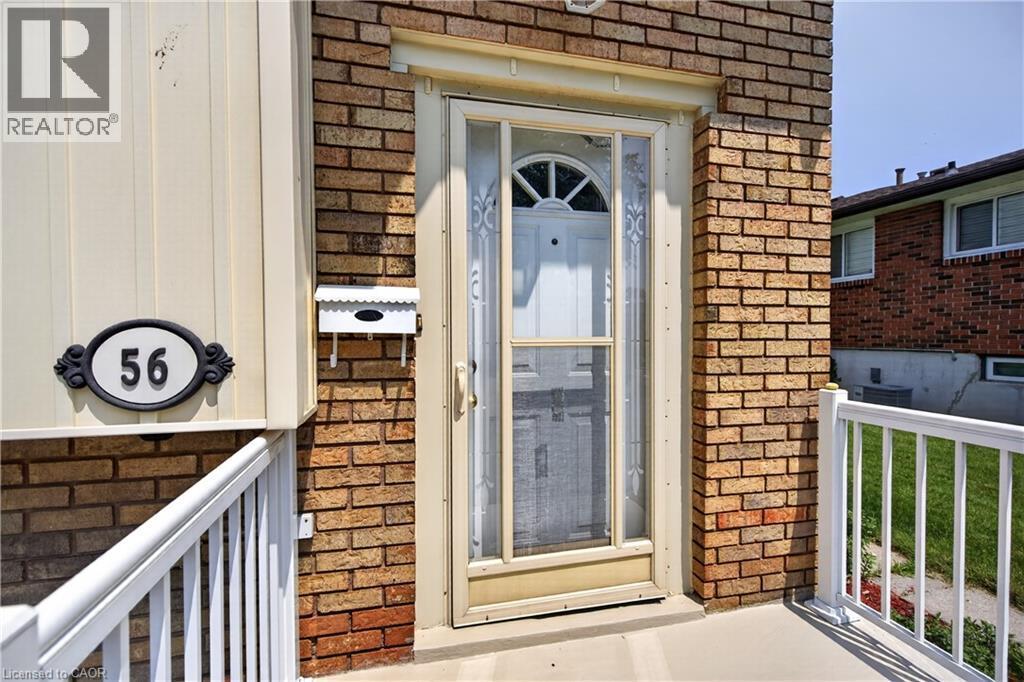 Brick facade entrance featuring a white storm door, decorative address plaque, and a wall-mounted mailbox - 56 Brookstream Court, Hamilton, ON - Outdoor With Deck Patio Veranda With Exterior