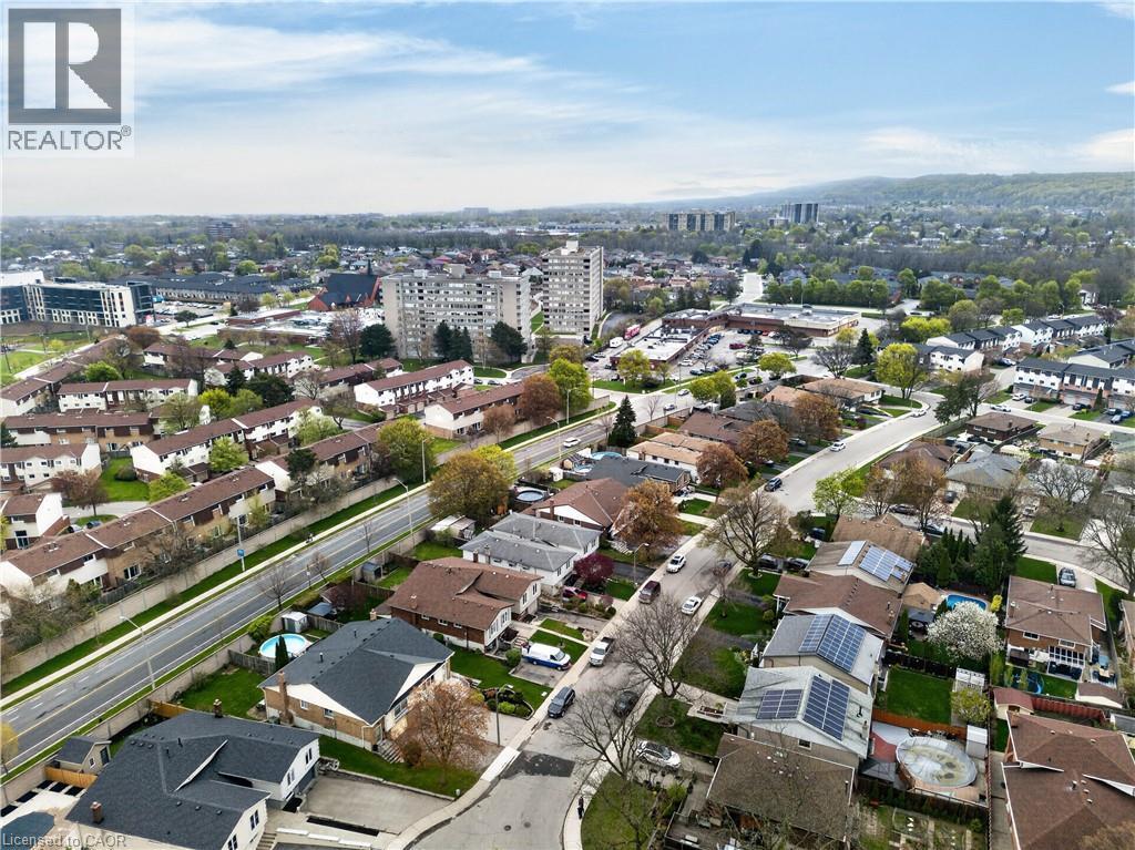 Aerial perspective showcasing a residential area with diverse architectural styles, including multi-story buildings and single-family homes - 56 Brookstream Court, Hamilton, ON - Outdoor With View