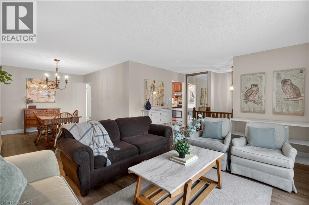 Open-concept living space featuring wood-finish flooring and neutral wall tones - 56 Brookstream Court, Hamilton, ON - Indoor Photo Showing Living Room