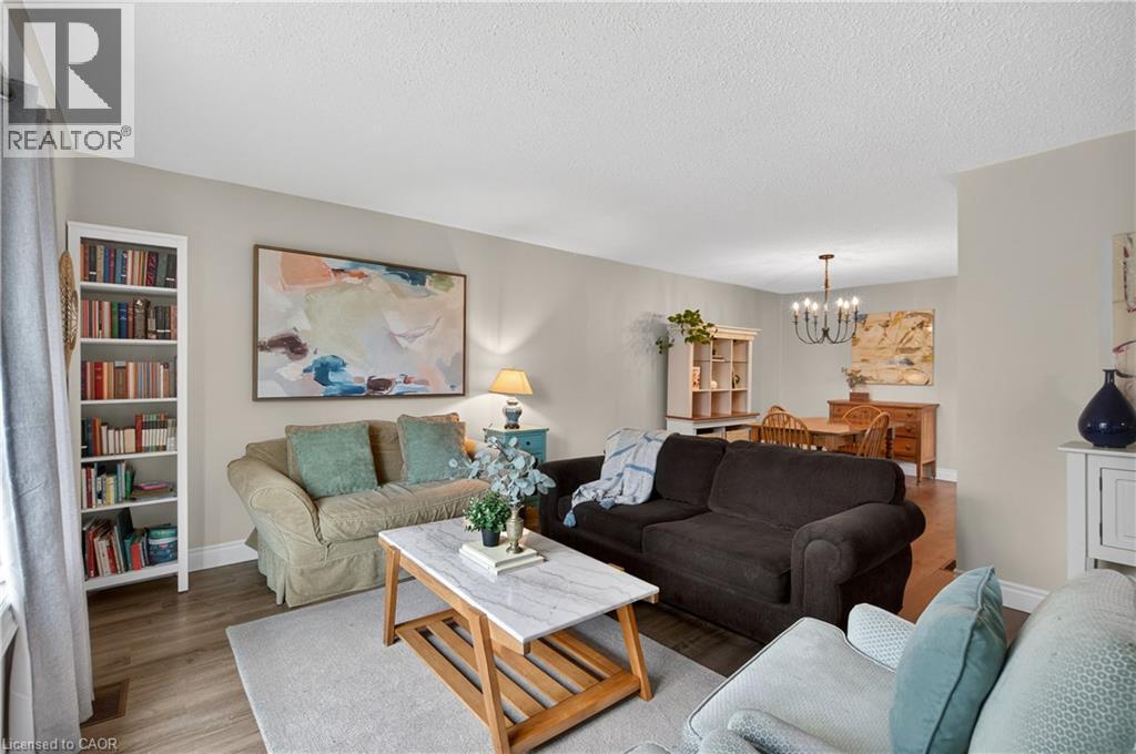Open concept living area featuring wood-finish flooring, light-toned walls, and a recessed ceiling - 56 Brookstream Court, Hamilton, ON - Indoor Photo Showing Living Room