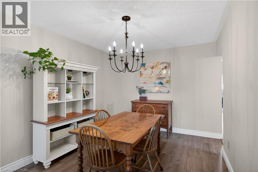 Dining area featuring dark wood-finish flooring, white baseboards, and light-toned walls - 56 Brookstream Court, Hamilton, ON - Indoor Photo Showing Dining Room