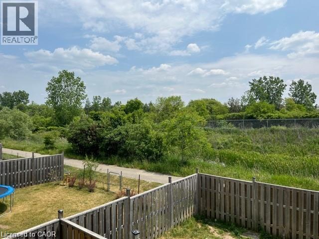 Private backyard with wood fencing bordering a natural green space and walking path - 300 Countrystone Crescent, Kitchener, ON - Outdoor