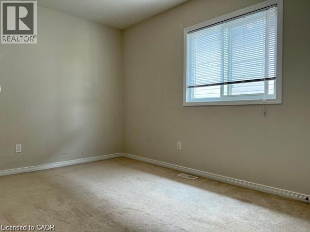 Carpeted room with neutral wall tones and a window featuring horizontal blinds - 300 Countrystone Crescent, Kitchener, ON - Indoor Photo Showing Other Room
