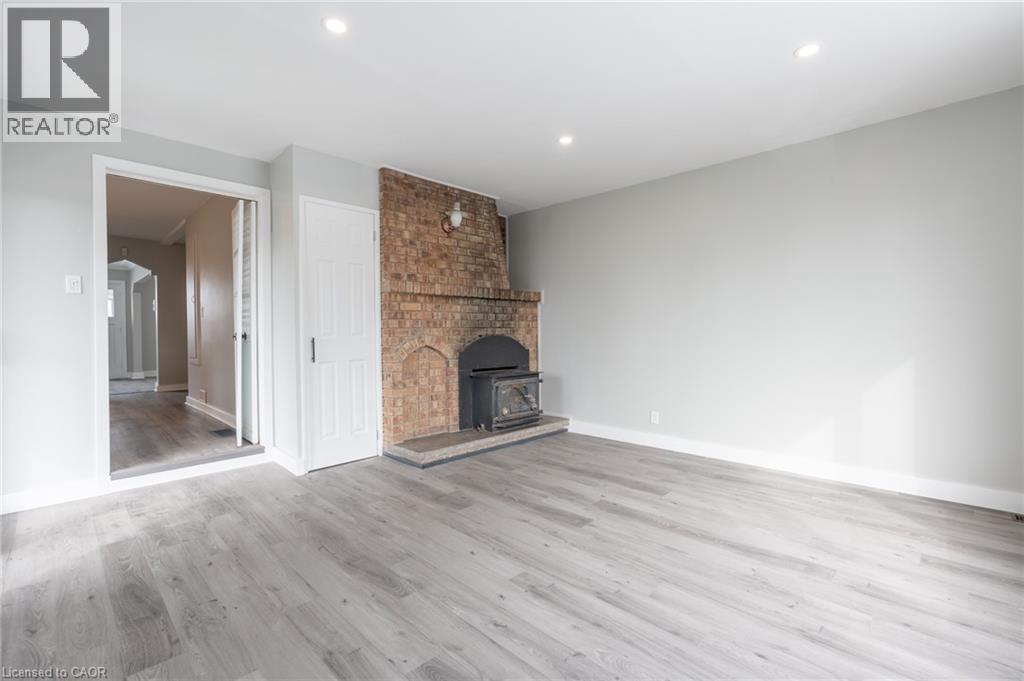 Spacious room featuring light gray walls and wood-finish flooring - 156 Adeline Avenue, Hamilton, ON