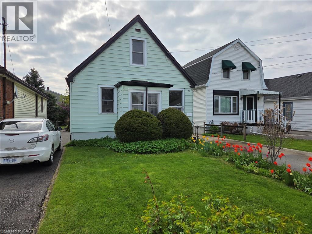 Mint green siding exterior featuring a prominent gabled roofline and a front bay window - 156 Adeline Avenue, Hamilton, ON