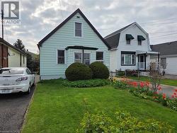Mint green siding exterior featuring a prominent gabled roofline and a front bay window - 