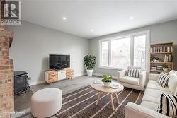 Spacious living area featuring light gray walls, recessed lighting, and wood-finish flooring - 