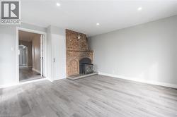 Spacious room featuring light gray walls and wood-finish flooring - 